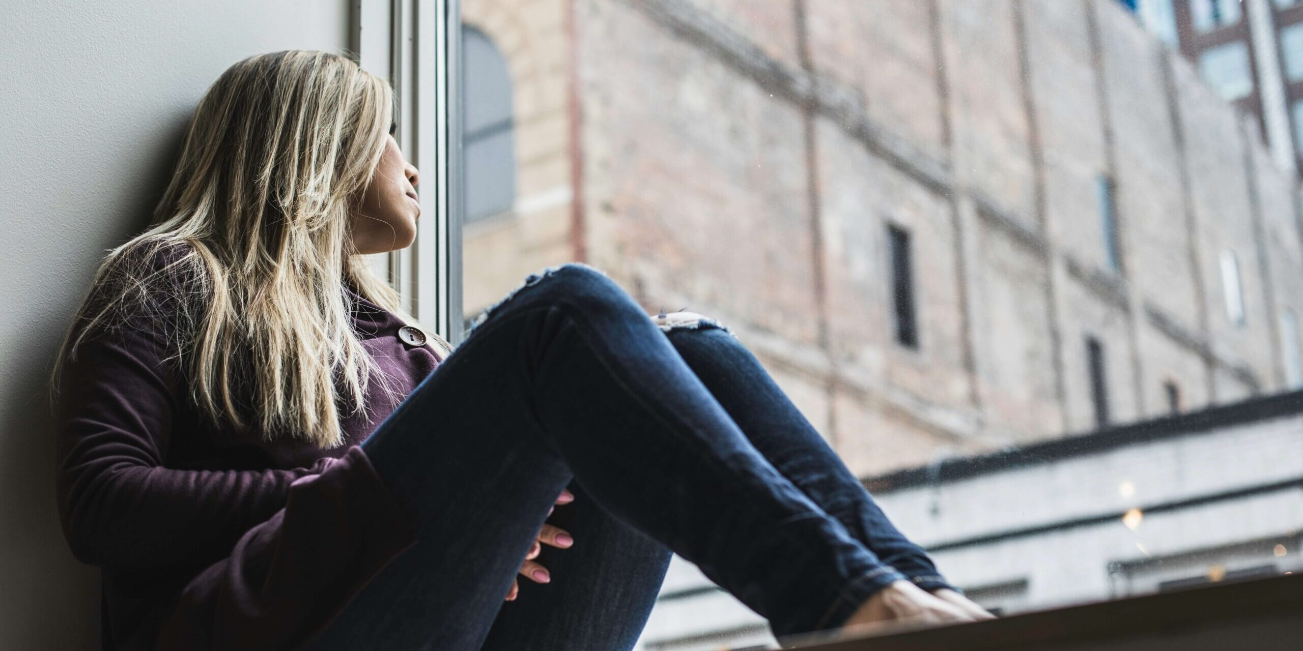 Person sitting calmly by a window, representing anxiety relief through exposure and ACT therapy in Denver.